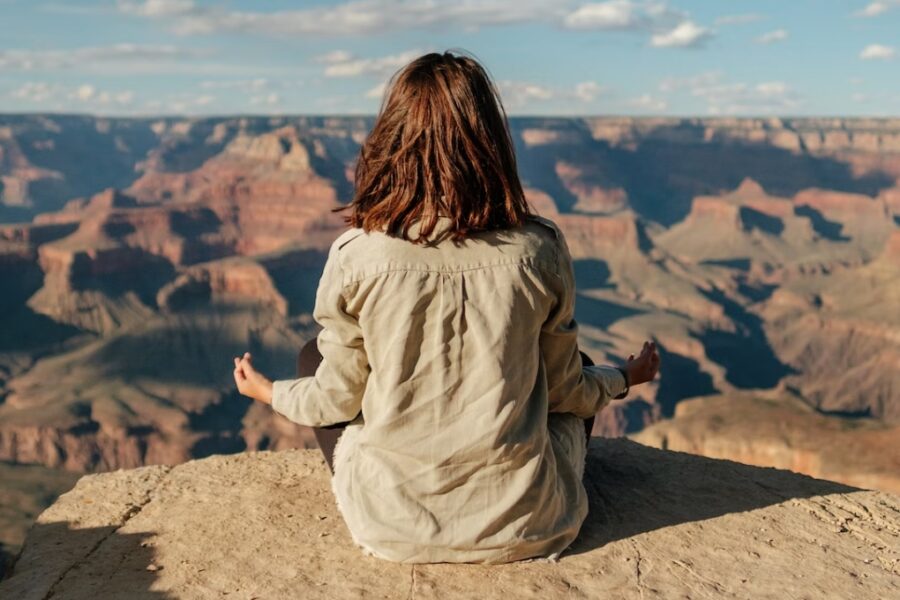 An image of a woman meditating in the mountains