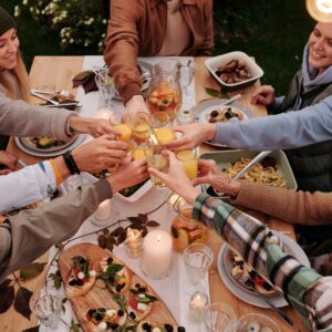 A group of people toasting with some drinks.