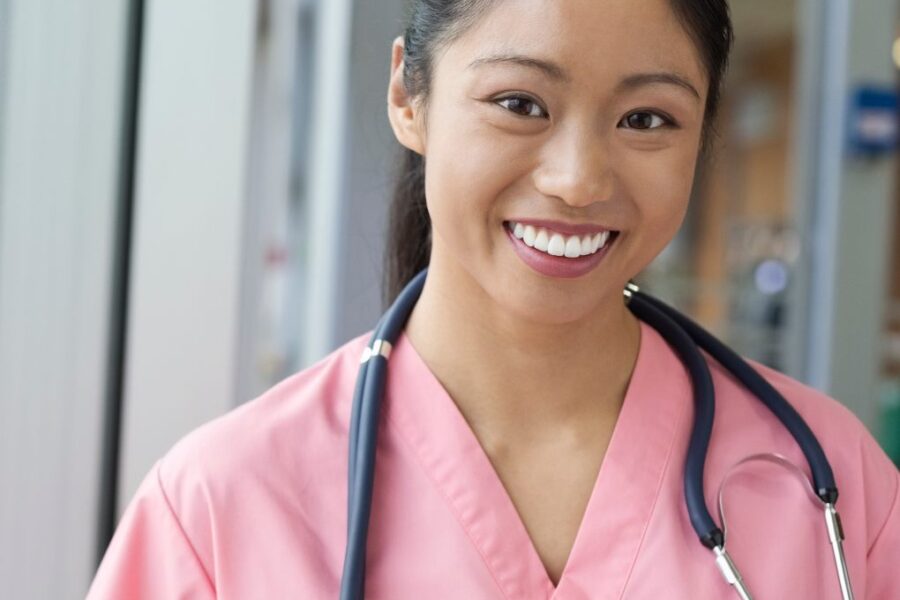 Smiling young female nurse in pink scrubs