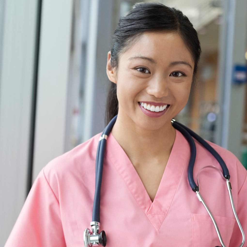 Smiling young female nurse in pink scrubs