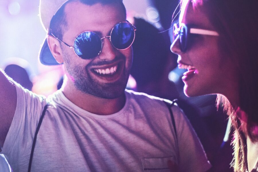 Photo of a young man and woman in sunglasses dancing in a Vegas nightclub.