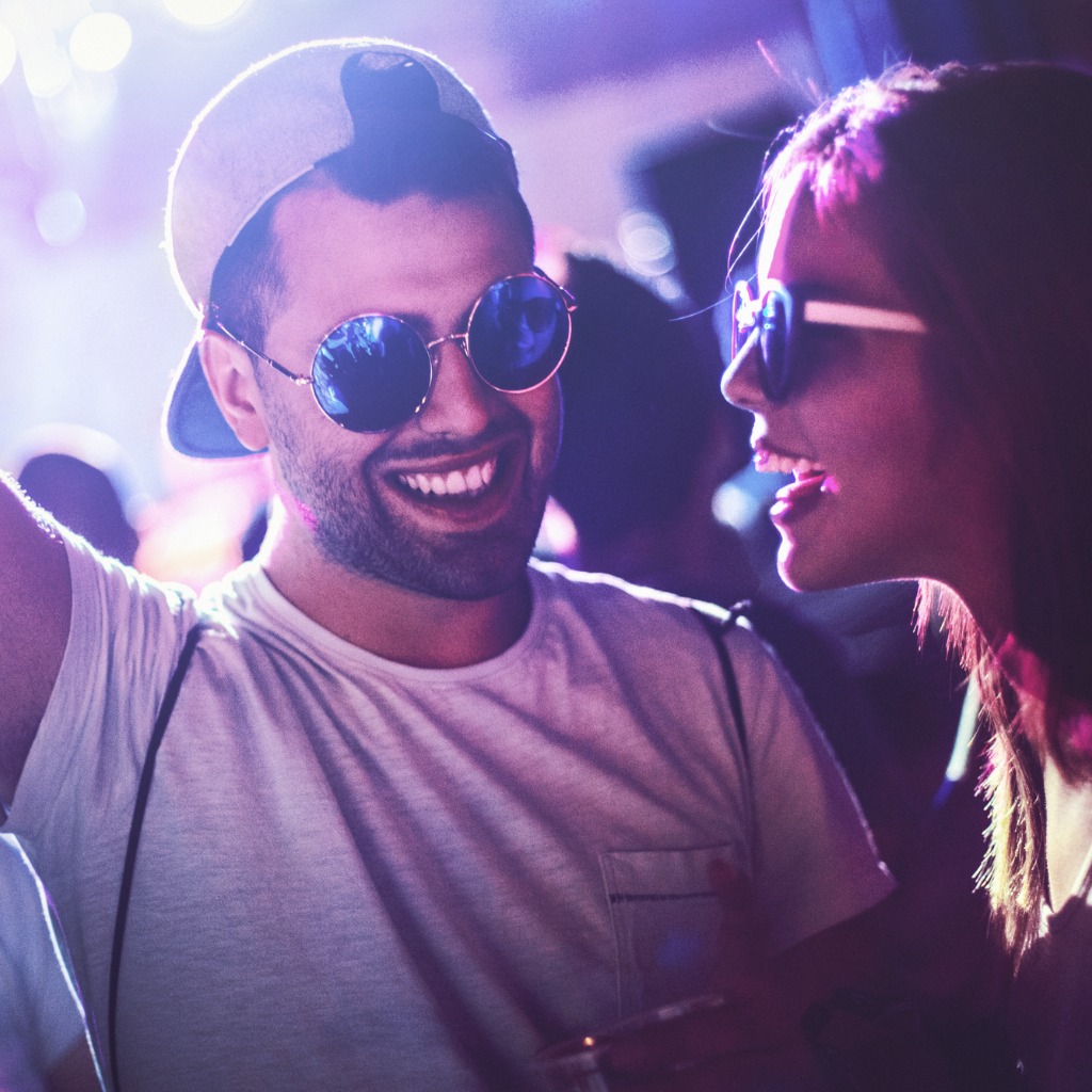 Photo of a young man and woman in sunglasses dancing in a Vegas nightclub.