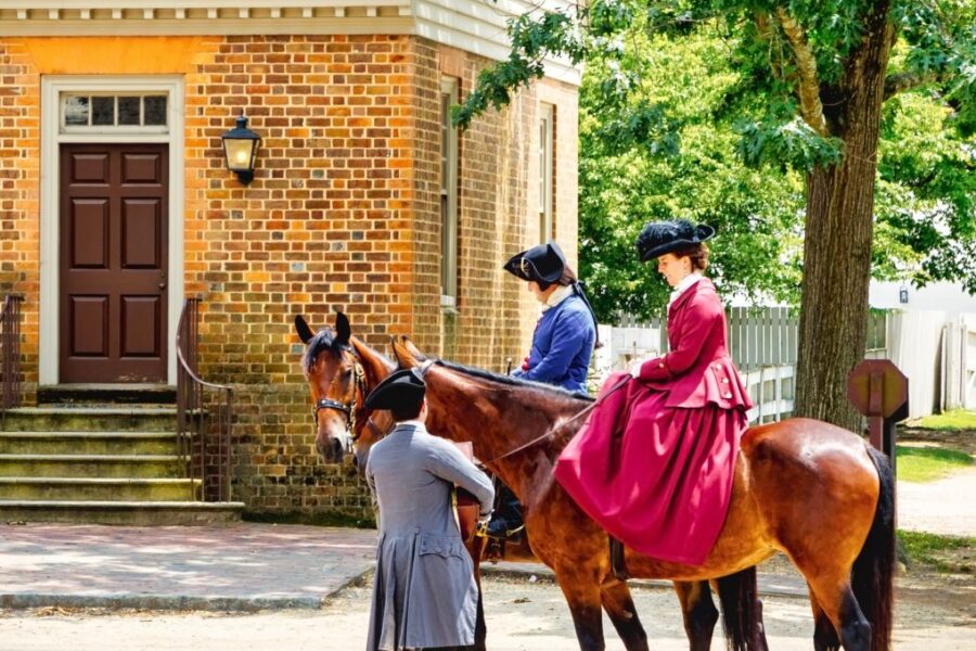 Williamsburg, Virginia / USA – June 30, 2016: Citizens of Colonial Williamsburg, in period clothing, meet in the street on horseback.