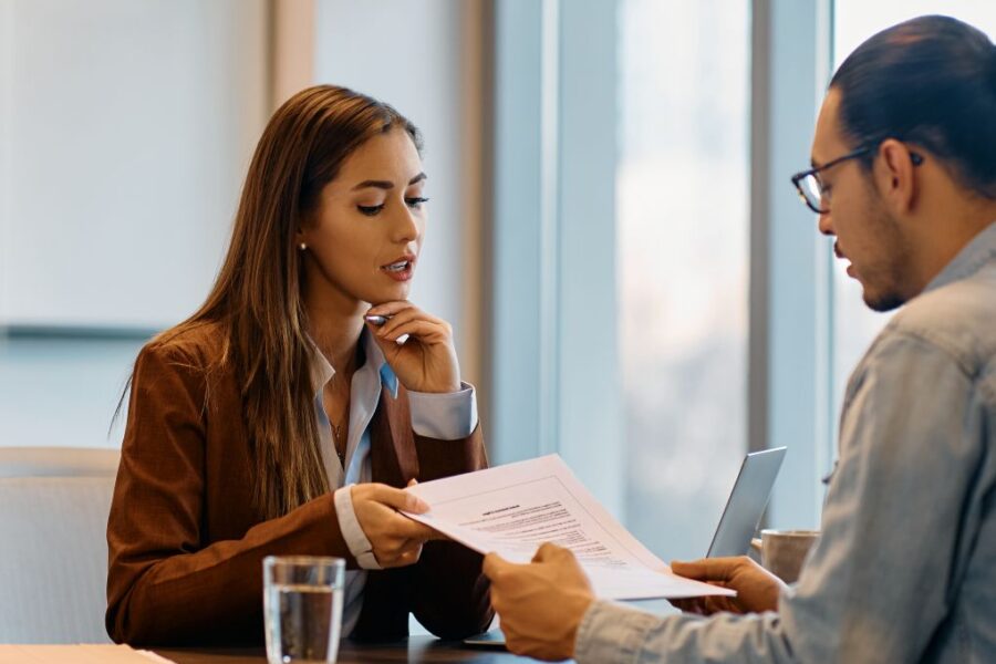 Young woman handing her resume to a recruiter.