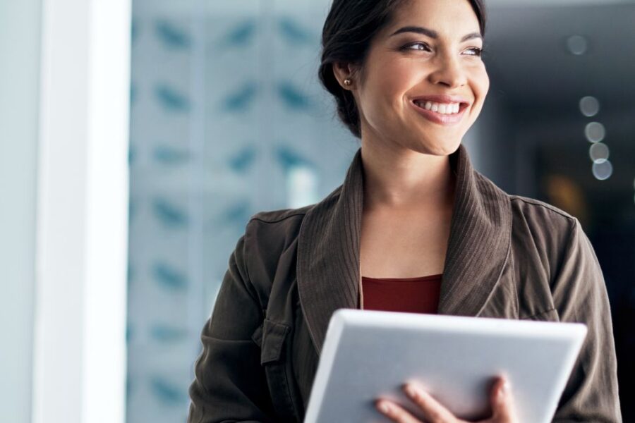 Young female government employee smiling and holding a tablet.