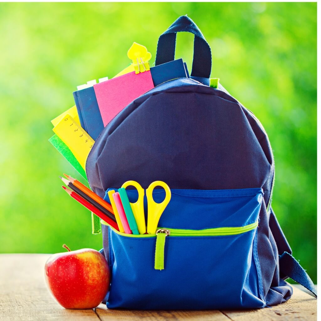 A blue backpack filled with back to school supplies.