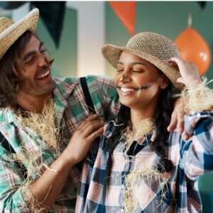 A young man and woman in homemade Halloween costumes dressed as scarecrows.