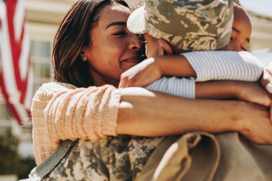 A military spouse and child saying goodbye to a deployed family member.