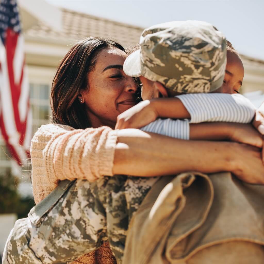 A military spouse and child saying goodbye to a deployed family member.
