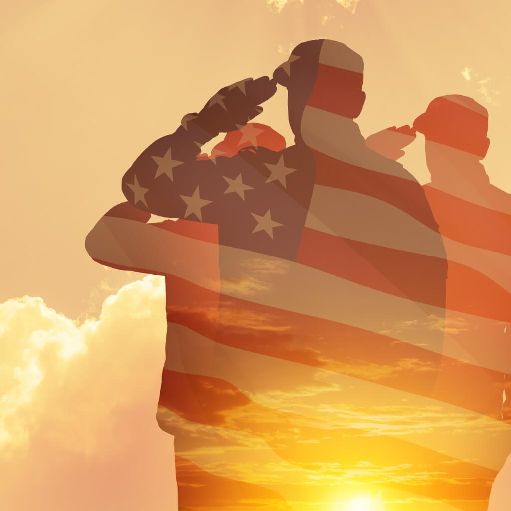 Silhouette of three US soldiers with an American flag superimposed over them, saluting and facing a sunset to honor Indigenous medal of honor recipients.