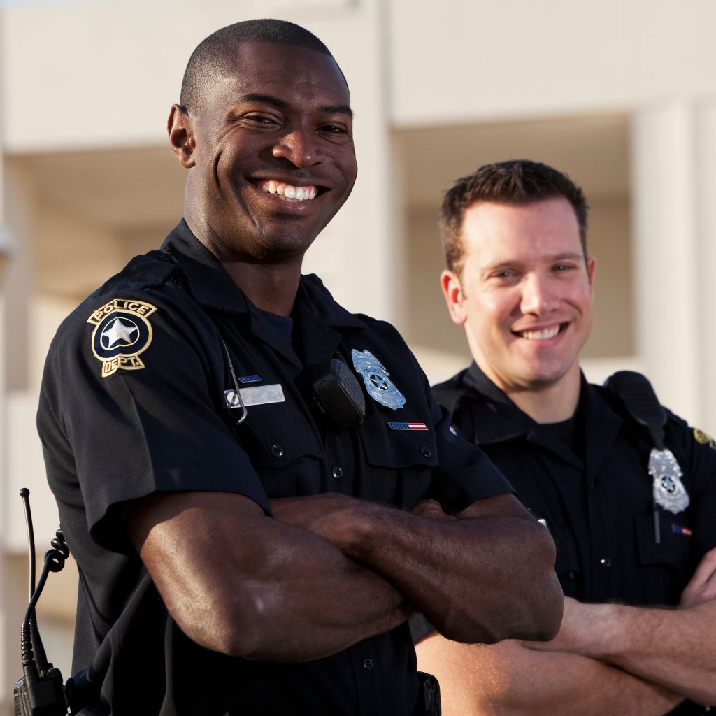 Two smiling police officers in uniform